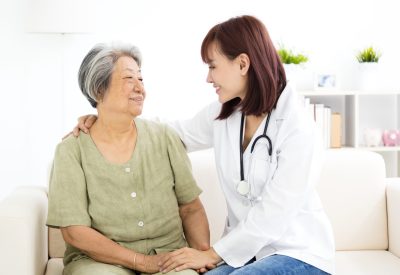 young smiling home caregiver  with senior woman