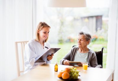 Health visitor and a senior woman with tablet.