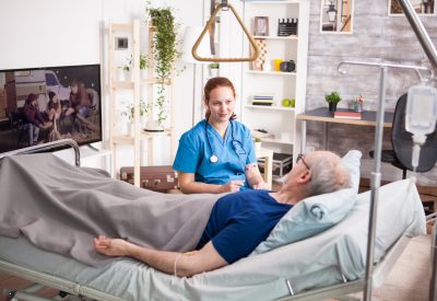 Female doctor with stethoscope sharing comfort to old man