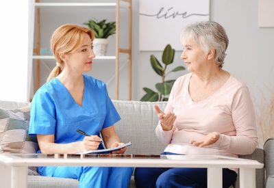 Elderly woman suffering from mental disability and caregiver in