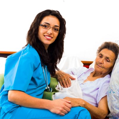 Happy joyful nurses caring for kind elderly patients helping their days in nursing home.