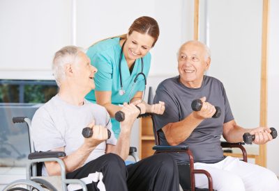 Senioren im Rollstuhl trainieren mit Hanteln