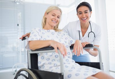 Doctor and patient in wheelchair smiling at camera